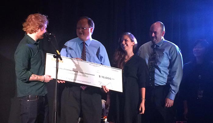 Ed Sheeran presented a check for $10,000 from Chegg to UCF Department of Music faculty (left to right) Jeff Moore, director; and Dave Schreier, assistant director of bands. The money will be used to fund music student scholarships. (Photo courtesy of Nicole Huie)