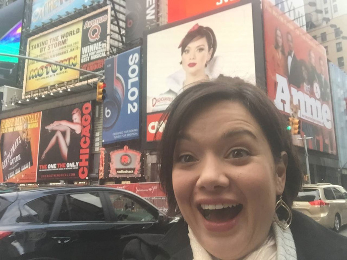 Michelle Knight, '02, poses in front of her Snow White billboard in Times Square. 
