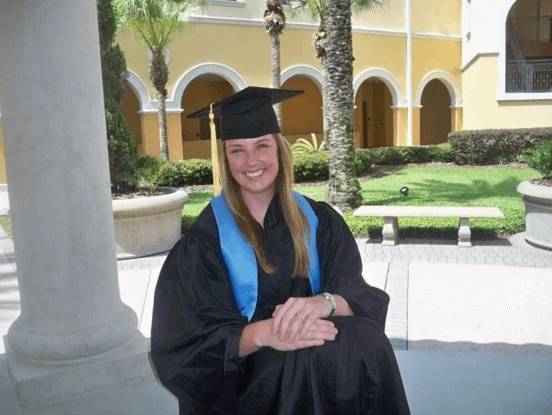 UCF alumna poses for photo in graduation regalia