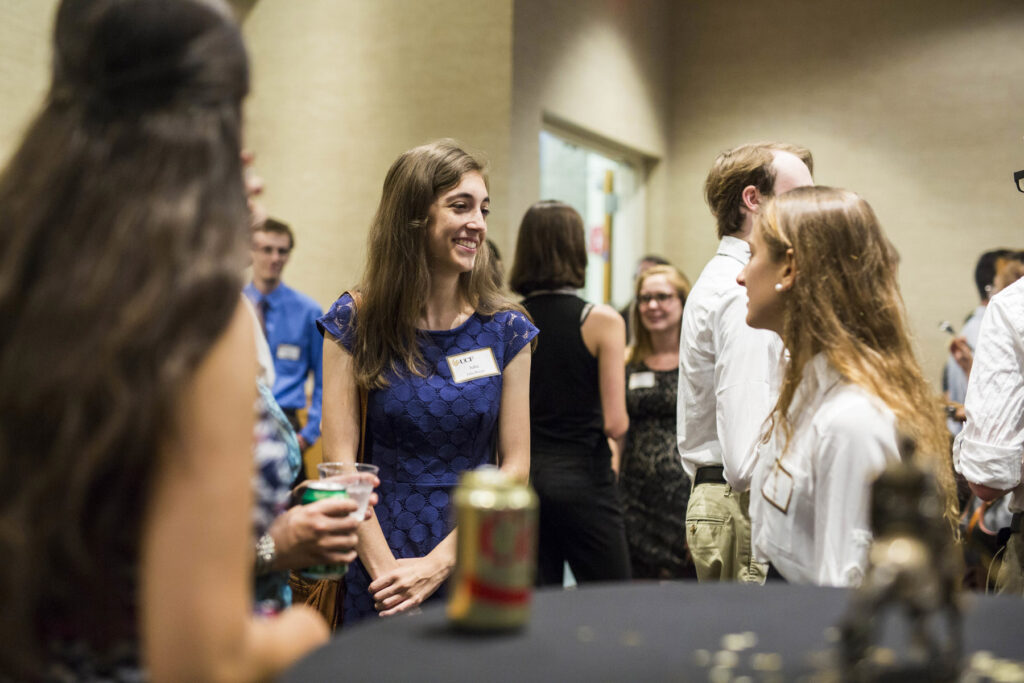 A photo of a group of happy alumni networking at an alumni event