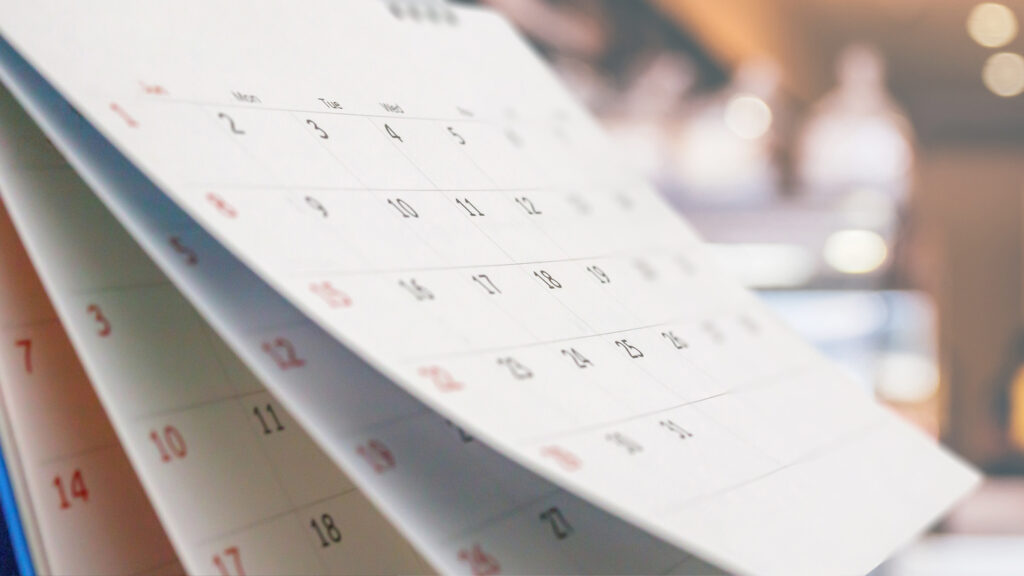 Close up white paper desk calendar with blurred background
