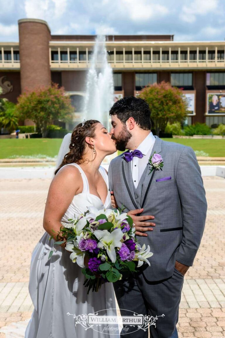 couple in wedding clothes in front of fountain