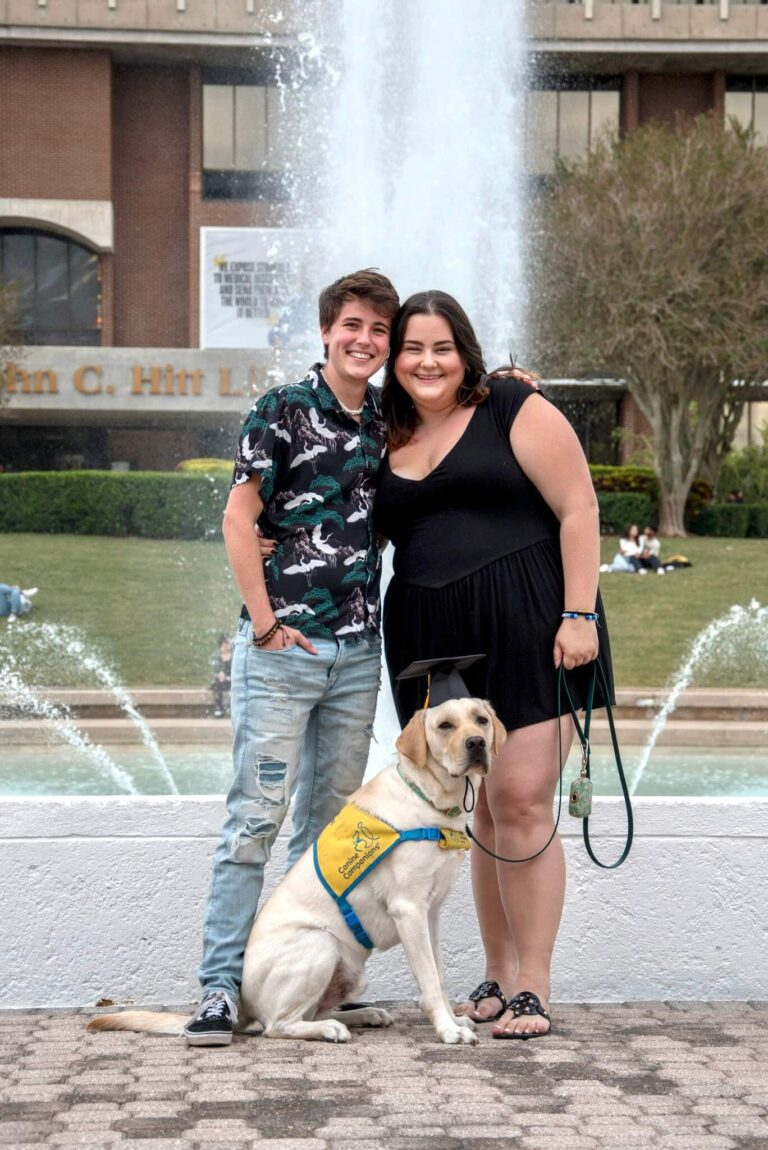 couple and dog in front of fountain