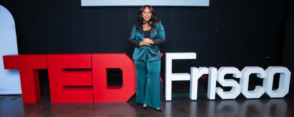 woman standing on stage at ted talk