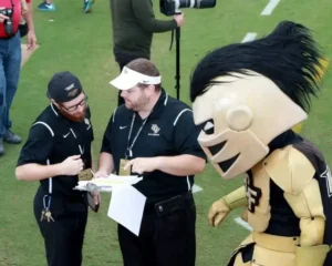 on the field wih two people and ucf mascot