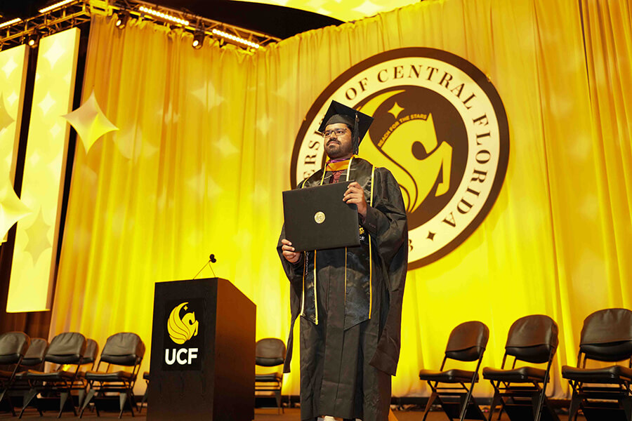 UCF Grad Walk image of graduate on stage