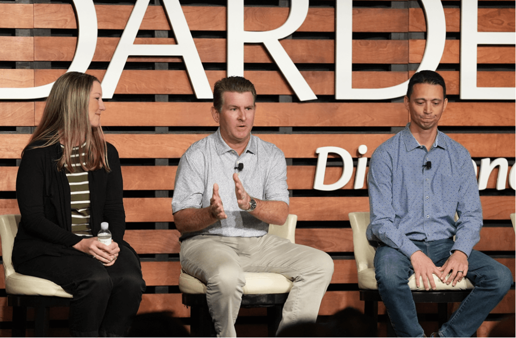 three people sitting on a stage