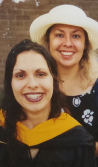 two women one of whom is in graduation regalia