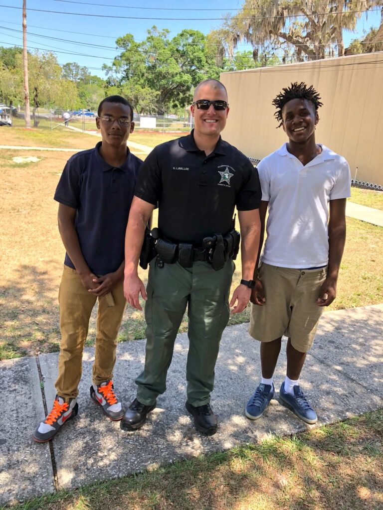 police officer and two young people smiling