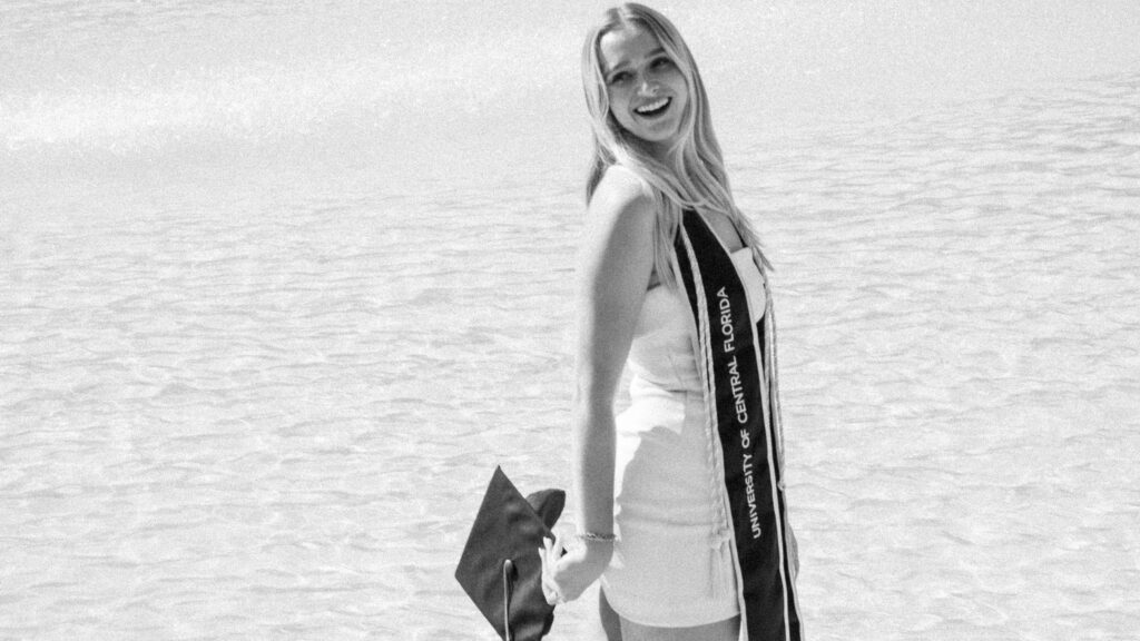 woman standing in reflection pond after graduation