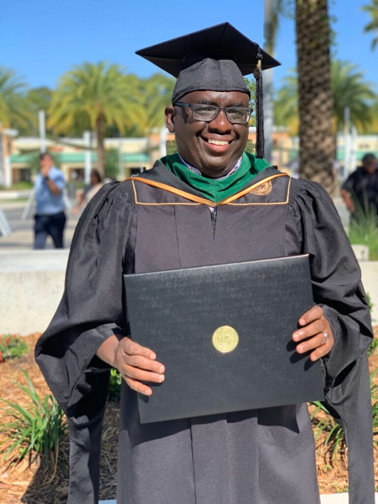 man with diploma dressed in regalia