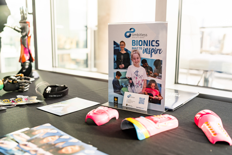 Promotional display for BIONICS Inspire by Limitless Solutions on a table, with pink robotic hands and brochures nearby.