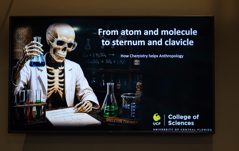Skeleton in a lab coat holds a flask beside lab glassware, with the title 'From atom and molecule to sternum and clavicle.'