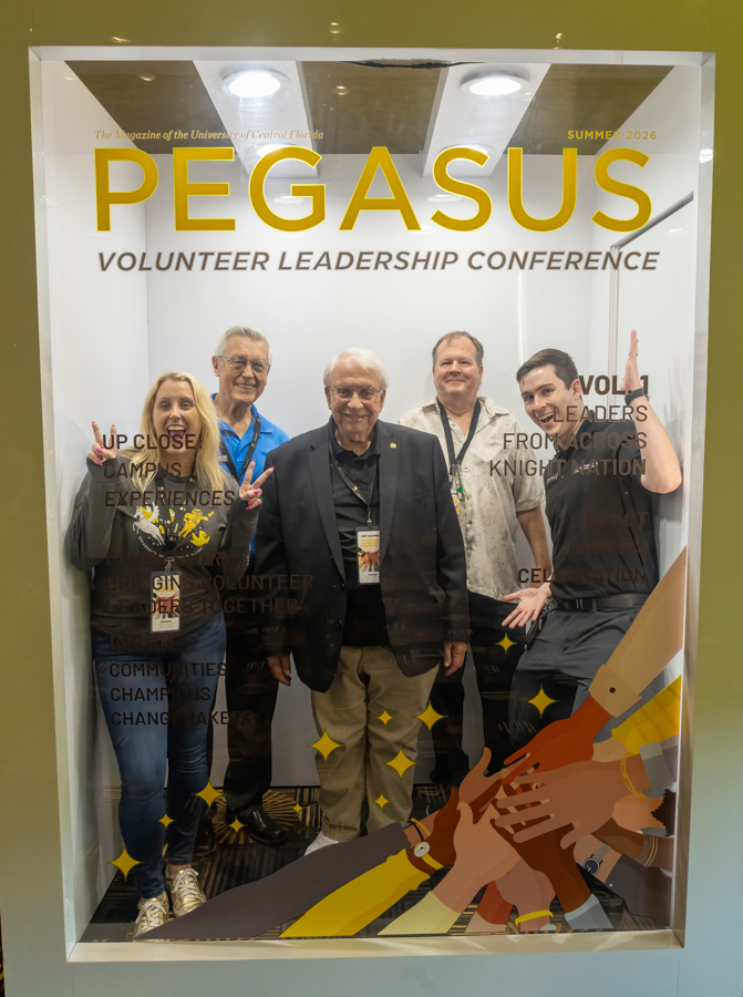Five adults posing inside a display booth with the word PEGASUS and 'Volunteer Leadership Conference' on a magazine cover, Summer 2026 issue.