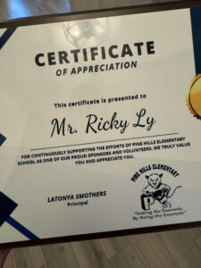 Certificate of appreciation awarded to Mr. Ricky Ly from Pine Hills Elementary, with the school principal Latonya Smothers and school logo nearby.