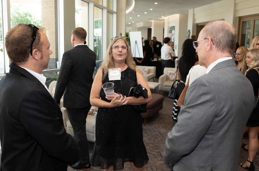 Group of professionals mingling in a bright lobby during a networking event in business attire.