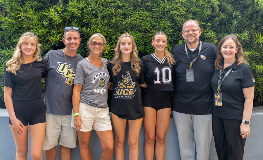 Group of six people posing outdoors, wearing UCF Knights apparel (team photo).