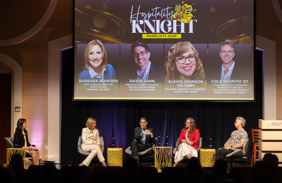 Panel discussion on stage at Hospitality Knight 2026 with five panelists seated in chairs; a large screen above shows their headshots and names.
