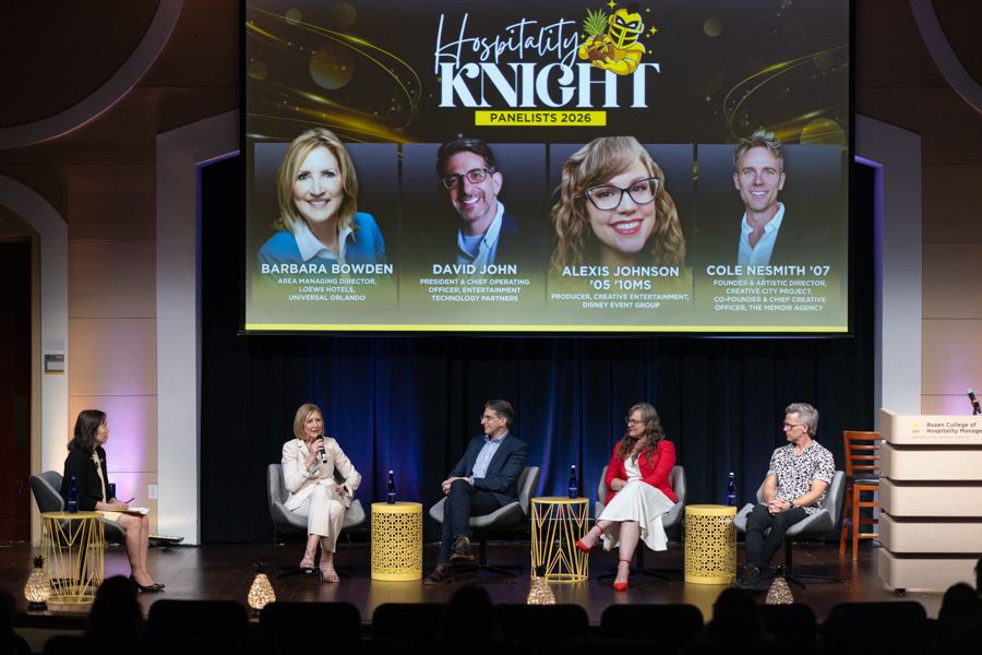 Five panelists seated on a stage in a conference setting, with a large screen above showing 'Hospitality Knight Panelists 2026' and headshots/names of the speakers in the banner.