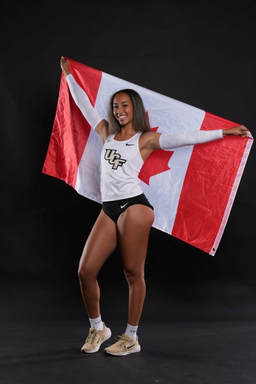 woman in ucf outfit holding a Canadian flag